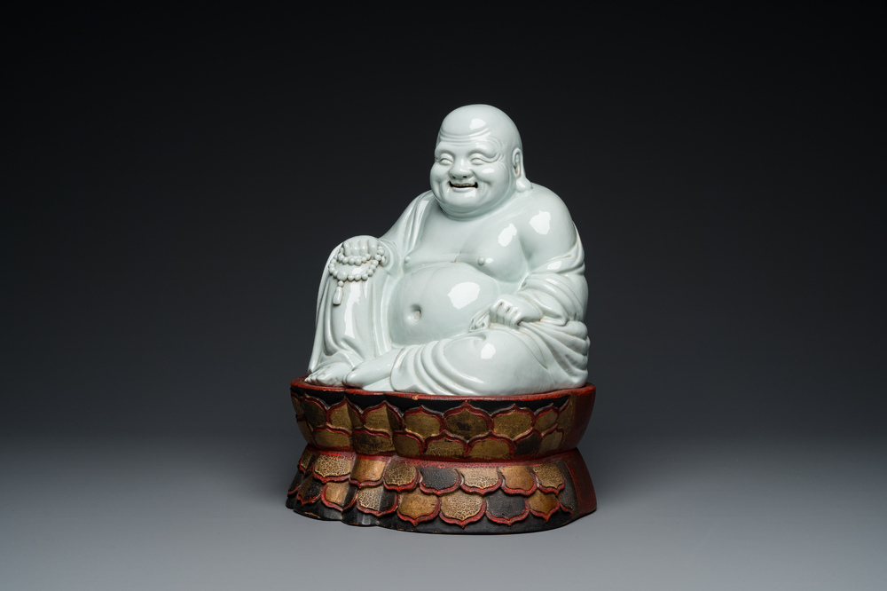 A Chinese blanc de Chine Buddha on lacquered and gilded wooden 'lotus' stand, Qianlong/Jiaqing