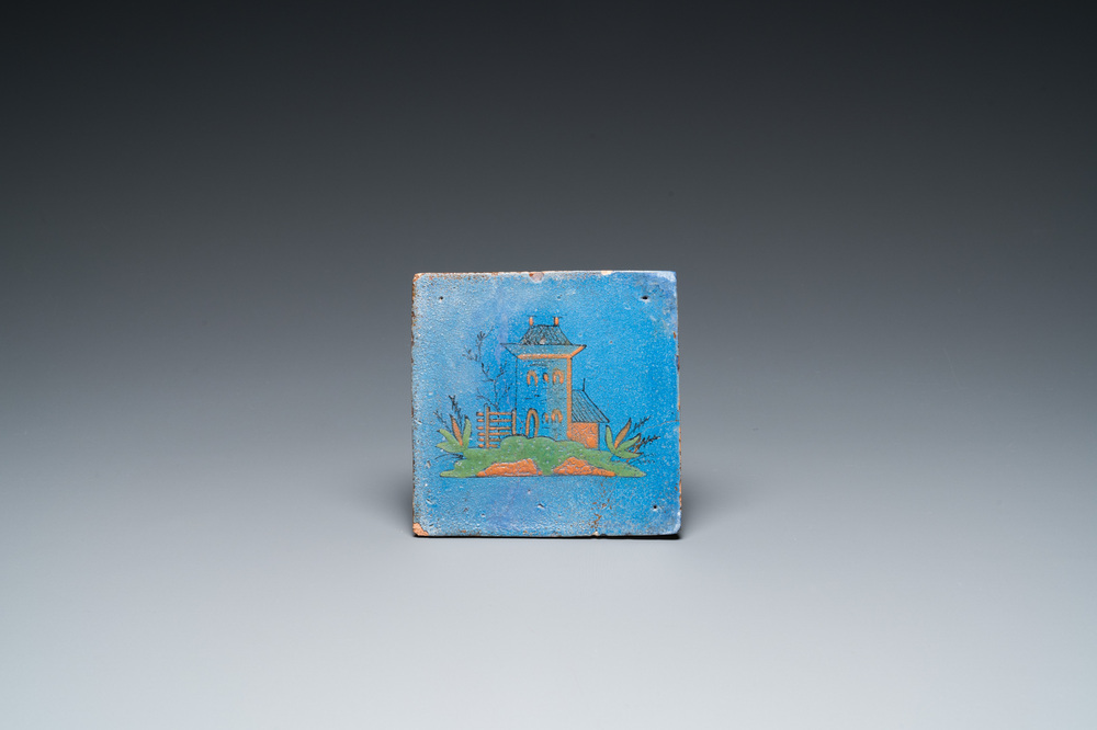 A rare polychrome Dutch Delft tile with a castle on a berretino blue ground, 17th C.