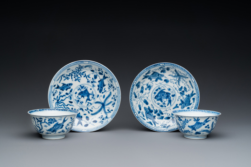 A pair of Chinese blue and white 'carps' cups and saucers, Kangxi