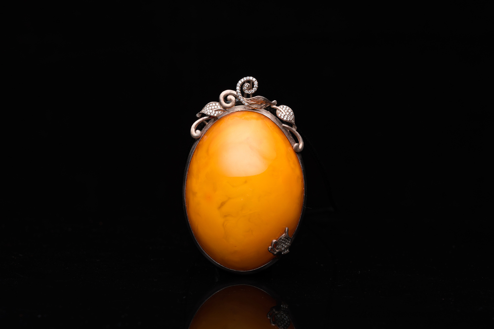 A Chinese silver and amber pendant, 20th C.