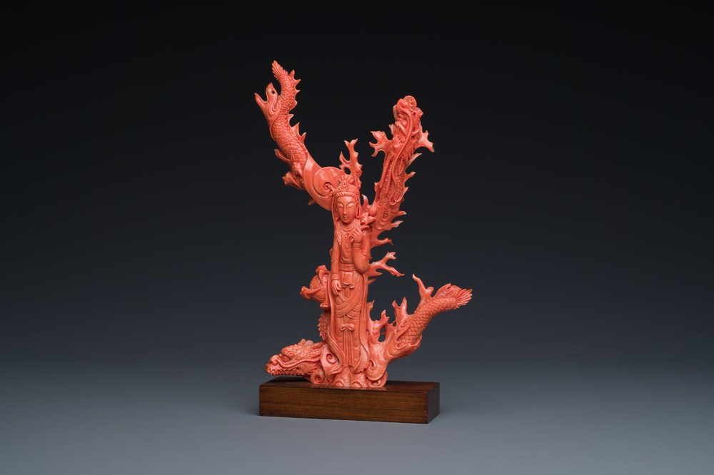 A Chinese red coral figure of a standing Guanyin with a dragon, 19/20th C.