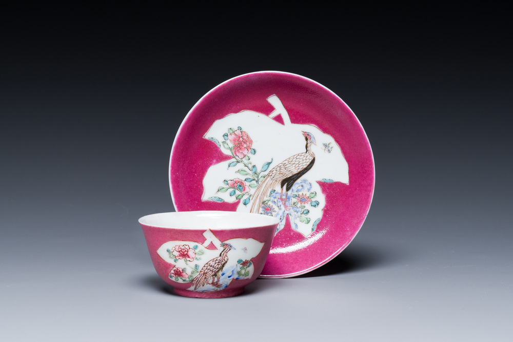 Een Chinese famille rose 'fazanten' kop en schotel met robijnrode fondkleur, Yongzheng