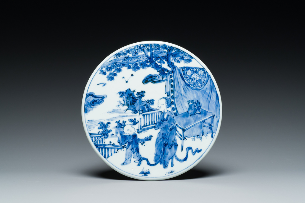 A Chinese round blue and white plaque with a lady and a boy, 19th C.