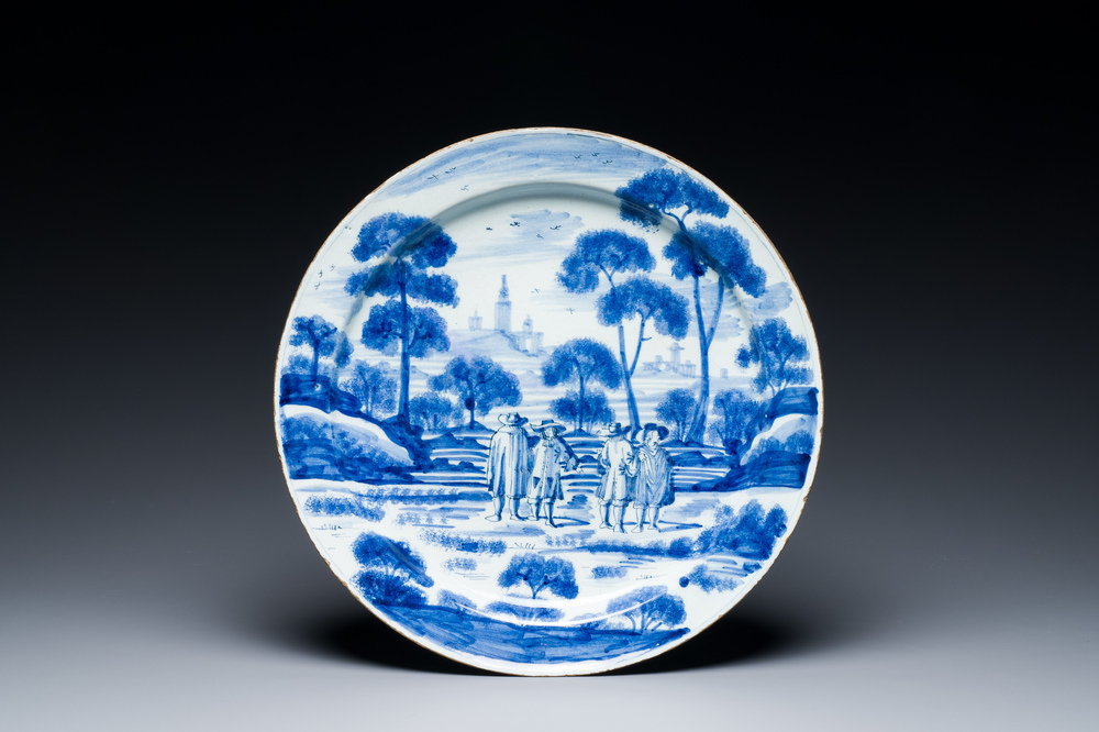 A large blue and white Dutch Delft dish with refined design of gentlemen in a landscape, 18th C.