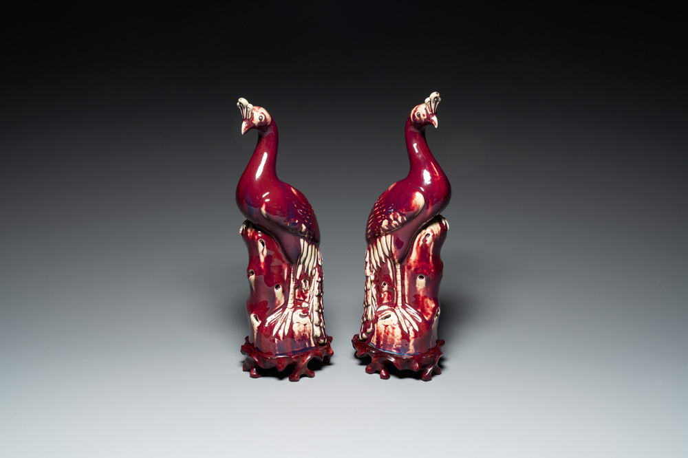 Een paar Chinese flamb&eacute; geglazuurde modellen van pauwen op houten sokkels, 19e eeuw