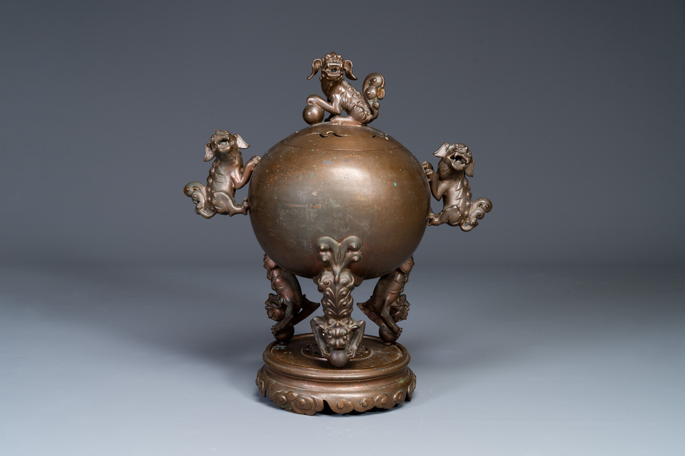 A large Chinese bronze censer and cover on stand decorated with six lions, 19th C.