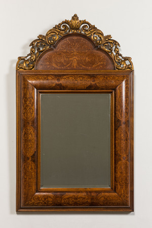 A wooden marquetry mirror with gilt wooden ornamental crown, 19th C.