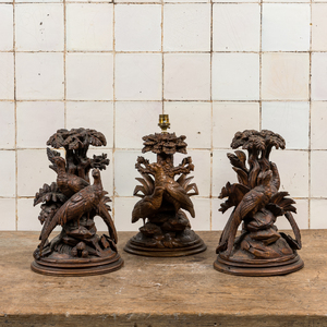 Trois sculptures 'de la Forêt Noire' en bois représentant des oiseaux sous des feuillages, dont une montée en lampe, la Suisse, vers 1900