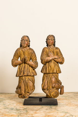 Een paar polychrome en vergulde houten geknielde en biddende engelen, ca. 1700