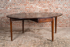 An oval English mahogany drop leaf table, 19th C.