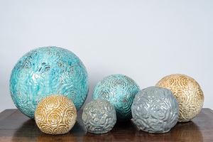 Six sphères en terre cuite émaillée à décor floral en relief, 20ème