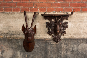 A carved wooden 'Black Forest' goat's head console and a carved oak head of a buck, Switzerland and/or Germany, 19/20th C.