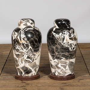 A pair of large black and white 'Grand Antique' marble vases and covers on red marble stands, Italy, 20th C.