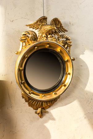 Miroir couronné d'un aigle en bois doré à médaillon intérieur noirci, vers 1900