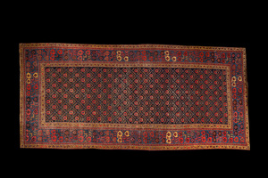 Un tapis oriental à motifs géométriques et décor floral, laine sur coton, 20ème
